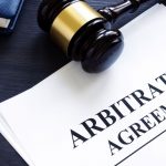 Arbitration agreement and gavel on a desk.